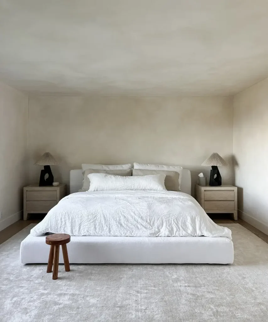 Neutral bedroom with textured limewash accent wall.
