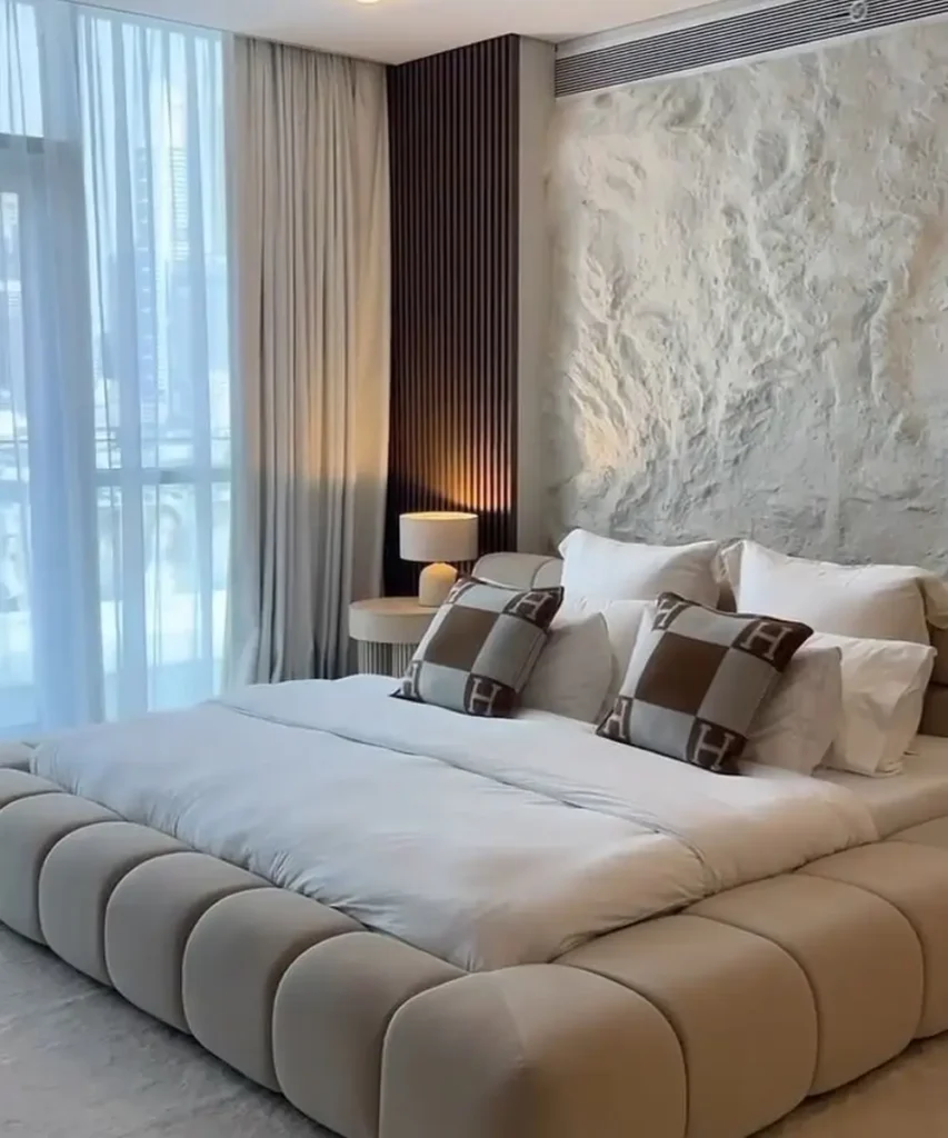 Neutral plaster accent wall creating a modern bedroom backdrop.